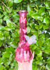 Side profile of the pink butterfly beaker bong on green background
