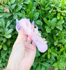 Side profile of the pink butterfly glass hand pipe on green