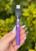 hand holding a purple vape outside