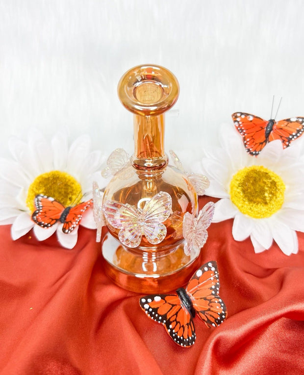 Amber iridescent butterfly dab rig with charms showing its back side view of the water pipe