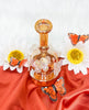 Amber iridescent butterfly dab rig with charms showing its back side view of the water pipe
