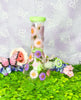Green dried floral bong with pink and purple flowers.