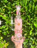 Pink double perc dried floral dab rig on green background
