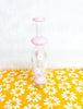 Pink milky nectar collector with white daisies on it