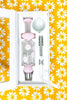 Pink milky nectar collector with white daisies on it in its box showing accessories