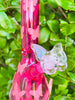 Up close of pink butterfly beaker bowl on green background
