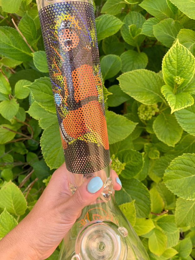 A person holding a naruto bong in front of a plant